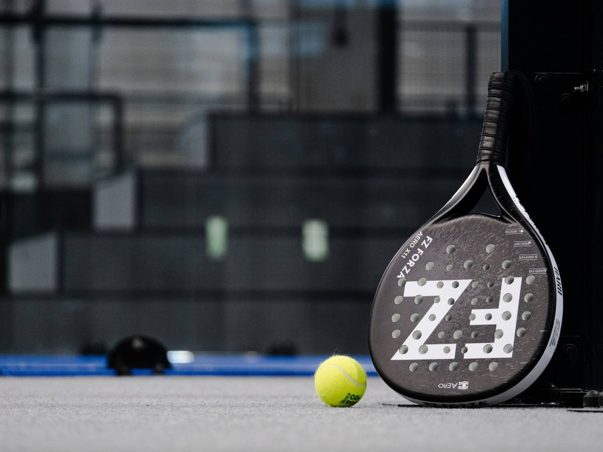 padel court dimension marked with tape measure showing full 20m x 10m rectangular playing area including perimeter walls and net placement